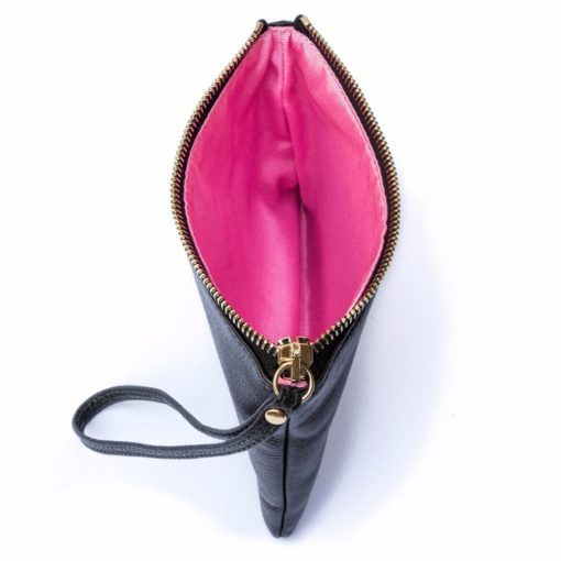A black leather purse with pink lining and wrist strap.