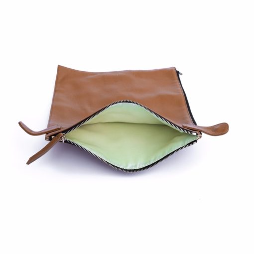 A brown leather purse with green lining.