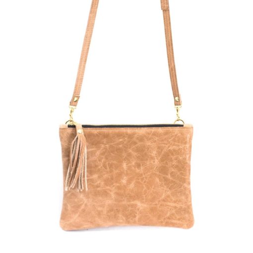 A tan purse with a tassel hanging from the front.