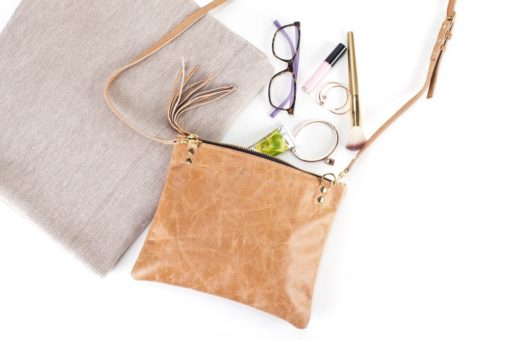 A purse with some glasses and makeup on it