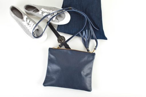 A blue purse and shoes on the ground