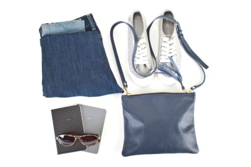 A purse, sneakers and sunglasses are laid out.