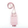 A pink purse with two pockets on the side.