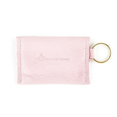 A pink wallet with a ring on the bottom of it.